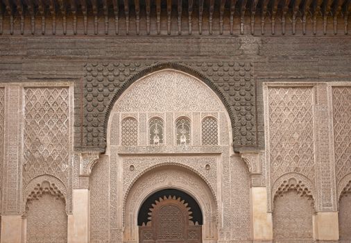 Ornate carving on the plastered walls and on the woodwork in the courtyard of the historic Ben Youssef Madrasa in the ancient heart of Marrakech in Morocco