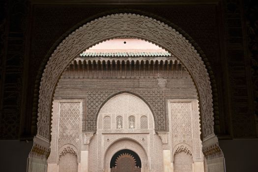 Ornate carving on the plastered walls and on the woodwork in the courtyard of the historic Ben Youssef Madrasa in the ancient heart of Marrakech in Morocco