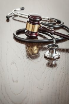 Gavel and Stethoscope on Reflective Wooden Table.