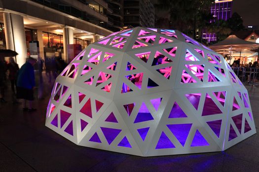 SYDNEY NSW, AUSTRALIA - JUNE 4, 2014;   People interacting and observing the Geodesic Light Dome  Circular Quay Sydney during Vivid Sydney Festival of Light Music and Ideas.  Strips of light, built into the structure will form waves of colour and light that will shift over and around the dome, encapsulating the viewer in a moment similar to standing in the brilliance of a stained glass window. 