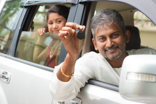 Indian man buying new car and showing the key, sitting in car. Asian family lifestyle.