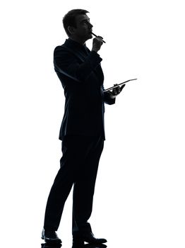 one caucasian business man thinking pensive holding digital tablet  in silhouette on white background