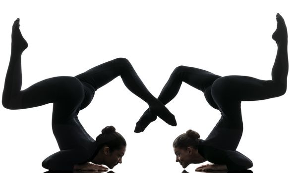 two women contortionist practicing gymnastic yoga in silhouette  on white background