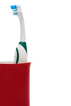 Toothbrush in a red glass on a white background