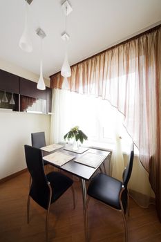 table and chairs by the window on the modern kitchen