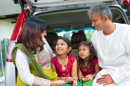 Happy Asian Indian family sitting in car talking and smiling happily, ready to summer vacation.