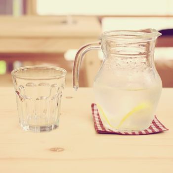 Jar of lemonade with empty glass for summer, retro filter effect