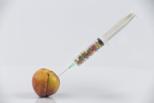 Female menopause and sexual disease metaphor: peach and syringe with meaning cosmetic and health treatment for female ageing