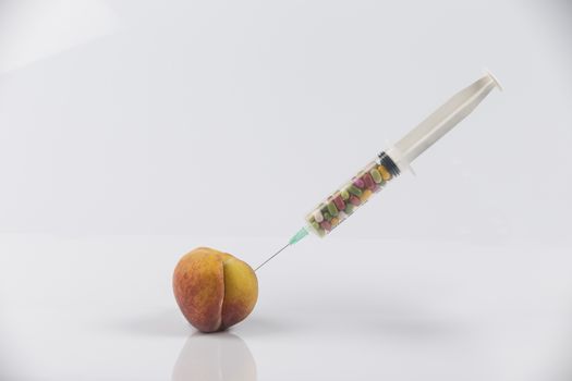 Female menopause and sexual disease metaphor: peach and syringe with meaning cosmetic and health treatment for female ageing