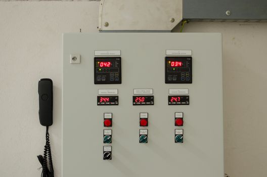 Switches buttons lights and phone on industrial control panel board.