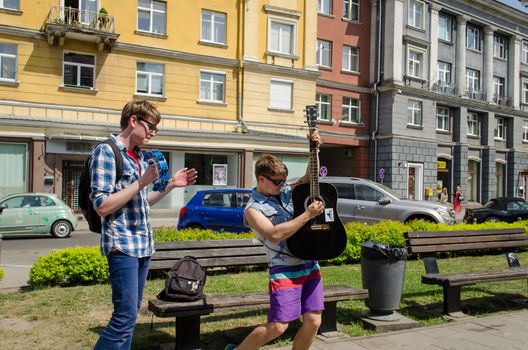 VILNIUS, LITHUANIA - MAY 18: cheerful active buskers with guitars and bell on city street on May 18, 2013 in Vilnius.