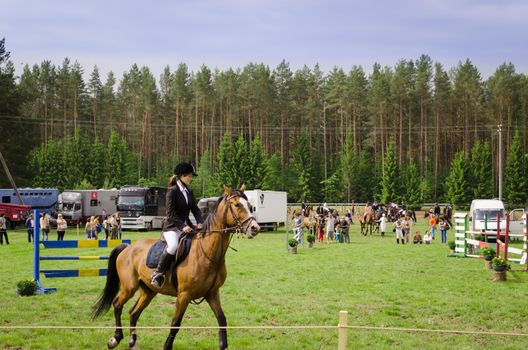 NIURONYS, LITHUANIA - JUNE 01: woman ride horse in horserace steeplechase competition on June 01, 2013 in Niuronys, Lithuania.