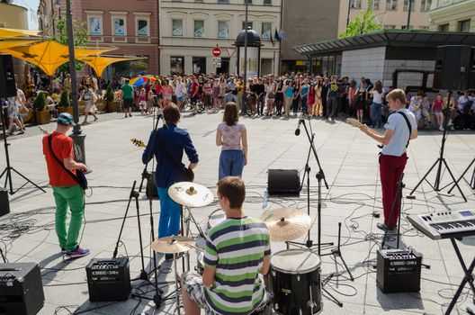 VILNIUS, LITHUANIA - MAY 18: back view of music group perform on street and lot of people listen to the concert on May 18, 2013 in Vilnius.