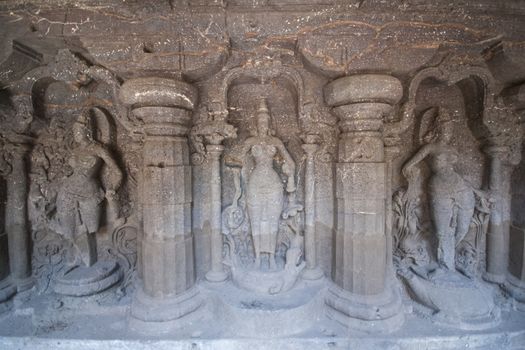 Religious figures carved into solid rock inside the ancient Hindu Temple (Kailas Temple) carved in rock. Cave number 16, Ellora Caves, India. 8th Century AD