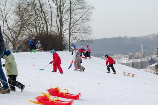 VILNIUS, LITHUANIA - JANUARY 18: active children recreation during the winter on the hill with sledge on January 18, 2014 in Vilnius, Lithuania. Winter time fun outdoor