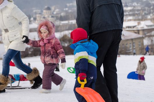 VILNIUS, LITHUANIA - JANUARY 18: children with parents playing in the winter park on January 18, 2014 in Vilnius, Lithuania. Winter landscape.