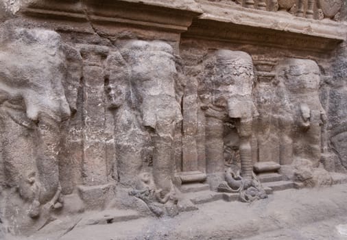 Row of elephants carved into solid rock along the base of a Hindu rock temple. Cave number 16, Ellora Caves, near Aurangabad, India. 8th Century AD