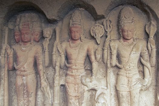 Images of the Hindu gods Brahma Vishnu and Shiva carved into solid rock inside an ancient cave temple Ellora Caves near aurangabad India.