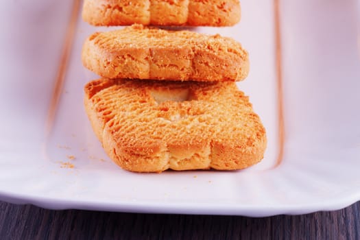 Biscuits over a white ceramic plate, over wooden table