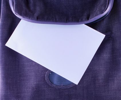 A white sheet of paper coming out of a backpack