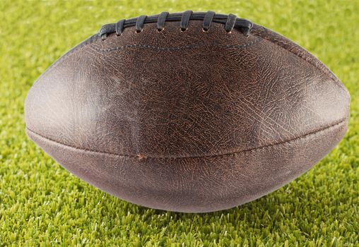 Leather football over a green grass field