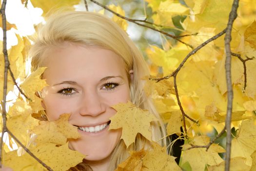 cheerful young blond woman  in autumn park