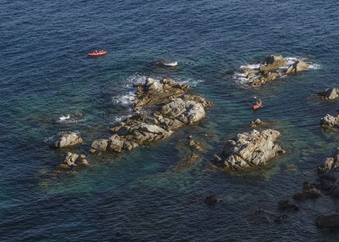 Tourists paddling in kayak among the rocks in the Costa Brava