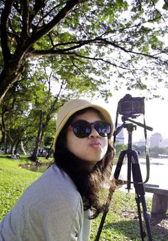 Young naughty asian girl with camera at public park
