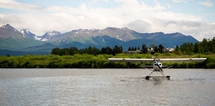 A bush plane performs taxi in in Alaska with Chugach Mountains in the Background