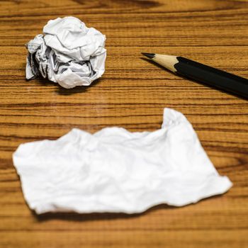 paper scrap and crumpled with pencil on wood background