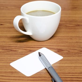 coffee cup and business card on wood background