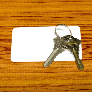 business card and keys on wood background