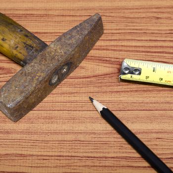 hammer measuring tape and pencil concept tools on wood background