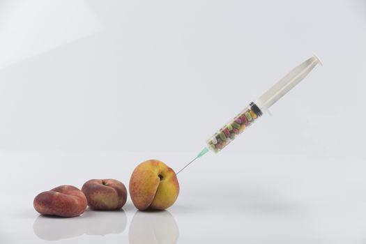 Female menopause and sexual disease metaphor: peaches and syringe with pills meaning cosmetic and health treatment for female ageing