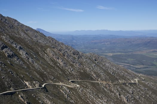 Gravel road hugging the side of a mountain en route to the Swartberg Pass in the Oudtshoorn region of the Western Cape in South Africa