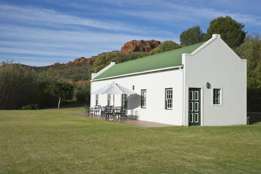 Farm cottage built in traditional Cape architectural style set in landscaped grounds in the Oudtshoorn region of the Western Cape in South Africa