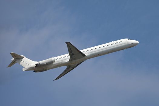 Airplane flying away to the blue sky