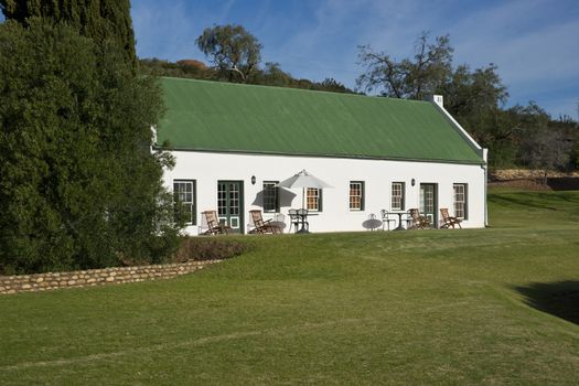 Farm cottage built in traditional Cape architectural style set in landscaped grounds in the Oudtshoorn region of the Western Cape in South Africa