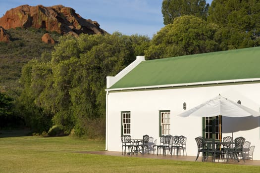 Farm cottage built in traditional Cape architectural style set in landscaped grounds in the Oudtshoorn region of the Western Cape in South Africa