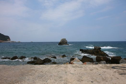 Coast and rock covered with birds near by Skopelos island,Greece