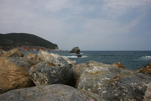Coast and rock covered with birds near by Skopelos island,Greece