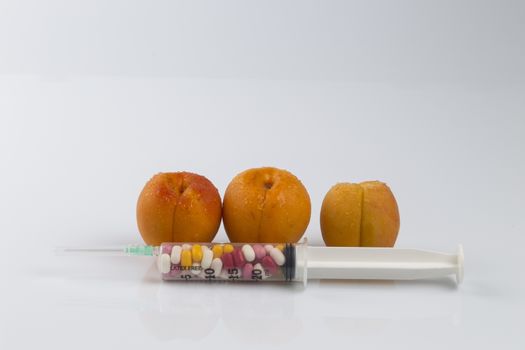 Female menopause and sexual disease metaphor: peaches and syringe with pills meaning cosmetic and health treatment for female ageing