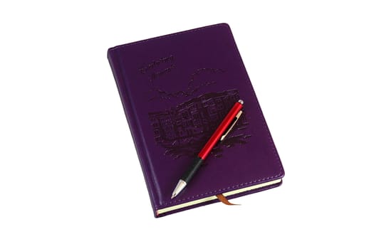 On a white background purple diary, on which lies a red pen to write it