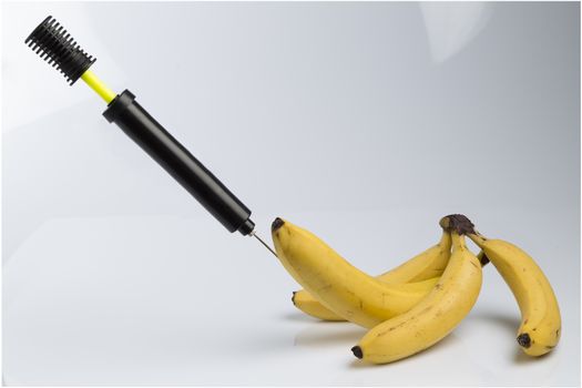 Male impotence metaphor: bicycle air pump pumping a  big banana among small bananas