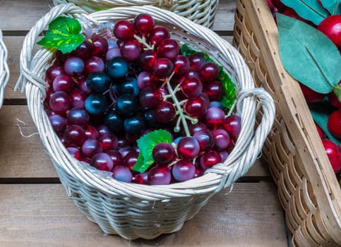 Collection of grapes with leaves in a wicker basket,