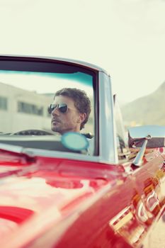 Handsome man driving a convertible car