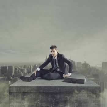 Young businessman falling to the ground with post apocalyptic cityscape on background.