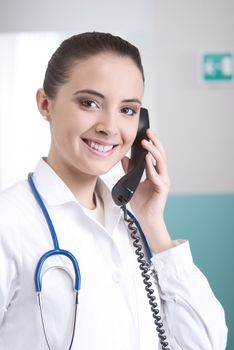 Young female doctor talking on the phone and smiling