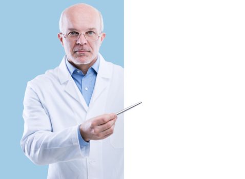 Senior doctor holding a big white sign and pointing with a pen, blank copyspace.