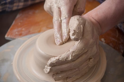 Hands of a potter, creating an earthen jar on the circle